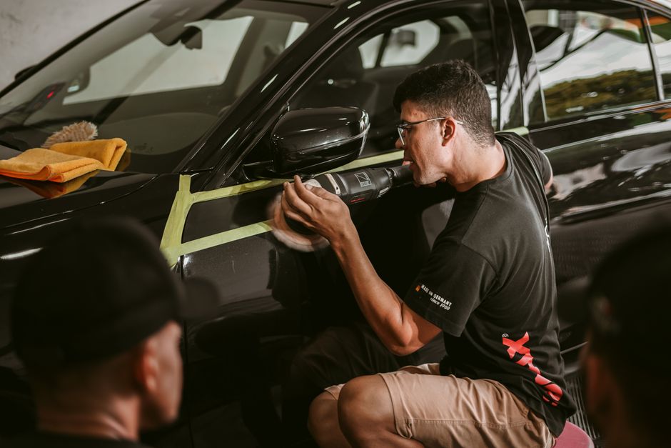 Professional auto detailer working meticulously on a vehicle